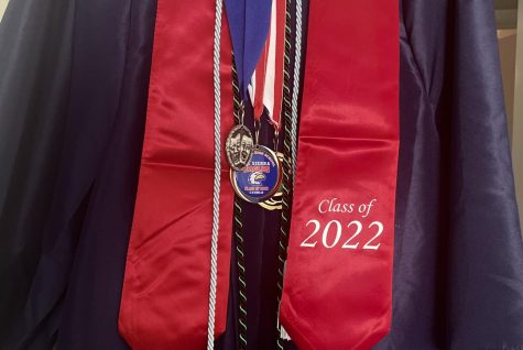 A blue gown with hanging cords and a stole is an example of how they looked and represented the accomplishments of senior students. 