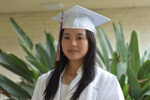 Wearing her white cap and gown, Cindy Luong smiles for the photo as she represents the Class of ‘22 for graduation.
