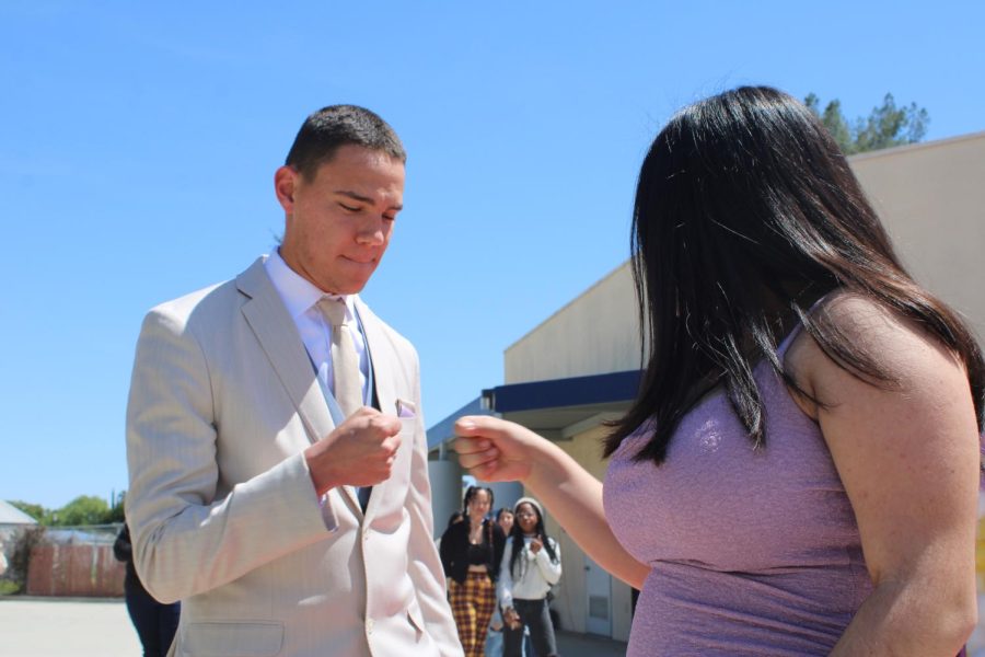 Quentin Martins does a handshake with red carpet partner Brianna Espinoza, junior, at the end of their walk. 
