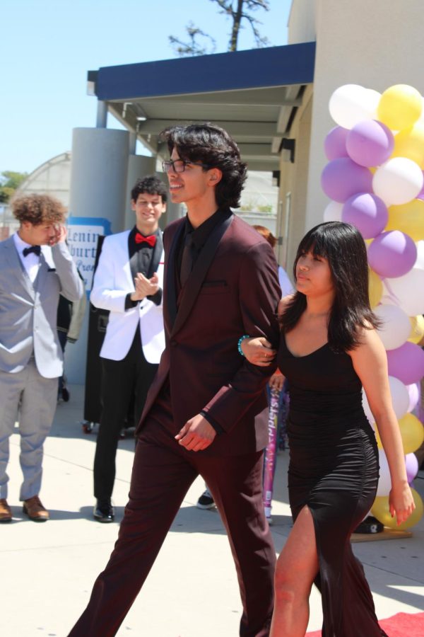Clad in a burgundy suit, senior Abel Rivera escorts fellow senior Isabel Coria, dressed in black, down the red carpet as the final couple.  