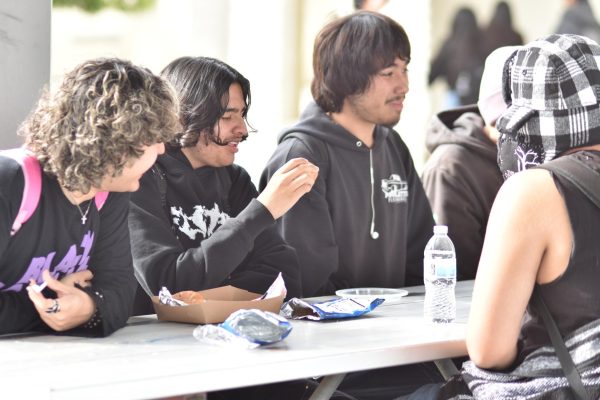 Nicolas Macias (12), Juan Amador Stewart (11), and Andrew Marquez (11) are seen laughing and talking as they enjoy lunch together.