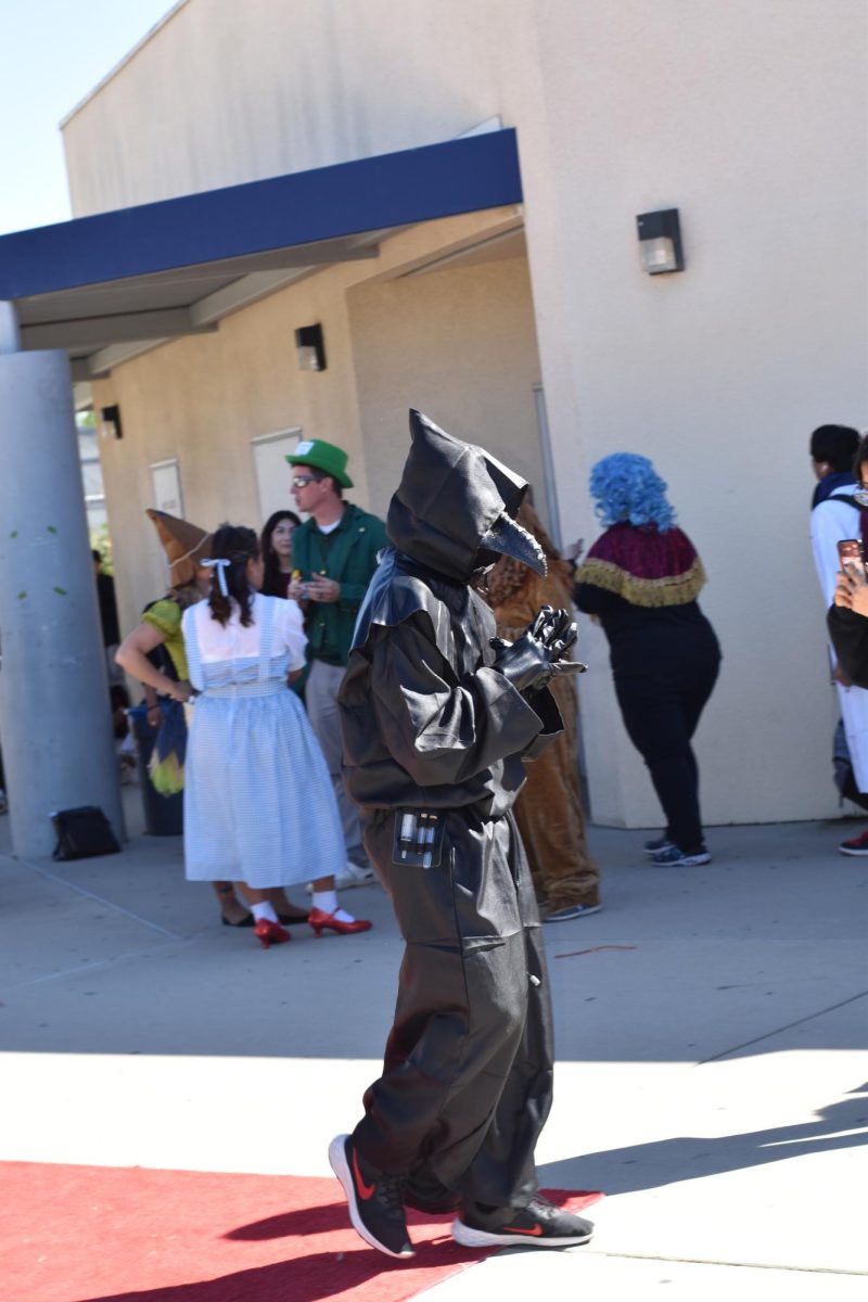 A student dressed as the Plague doctor fashionably walks along the Halloween Costume Contest Carpet.
10/31/23  Photographed and Written by Abraham Caudillo